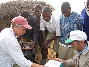 Thomas Smith in the field. Tom Smith (far left) in Uganda doing research on avian blood parasites with Gediminas Valkiunas from the University of Vilnius (right), and residents of the village of Western Uganda near Bwindi Forest National Park. Image credit: University of California