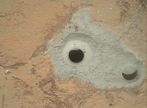 At the center of this image from NASA's Curiosity rover is the hole in a rock called "John Klein" where the rover conducted its first sample drilling on Mars. The drilling took place on Feb. 8, 2013, or Sol 182, Curiosity's 182nd Martian day of operations. Several preparatory activities with the drill preceded this operation, including a test that produced the shallower hole on the right two days earlier, but the deeper hole resulted from the first use of the drill for rock sample collection. Image credit: NASA/JPL-Caltech/MSSS
