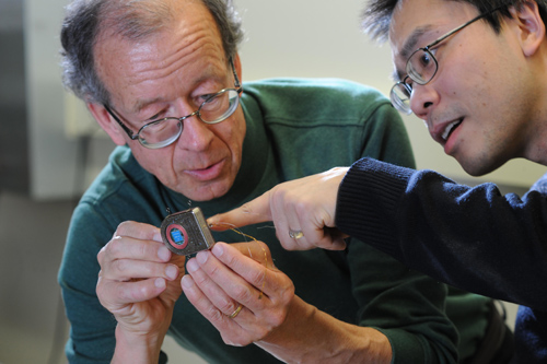 Cortex communication. Engineers Arto Nurmikko and Ming Yin examine their prototype wireless, broadband neural sensing device. Image credit: Fred Field for Brown University 