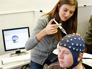 Erin Diamond prepares a volunteer for an EEG experiment. Image credit: University of Minnesota 