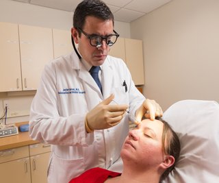 Javier Servat, MD, injects a Botox treatment. Photo by Robert Lisak