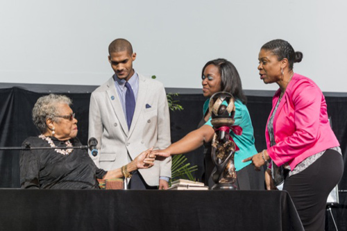 Maya Angelou is presented the gift of a statue by N'Kosi Oates, Brooklynn Hitchens and Kasandra Moye, director of the Center for Black Culture. Photos by Kathy F. Atkinson and Evan Krape