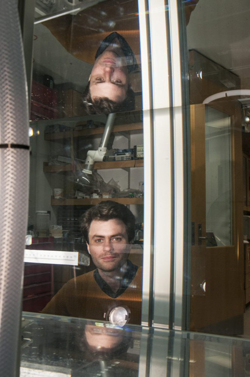 William Irvine, assistant professor in physics, peers through the experimental water tank in his laboratory at the Gordon Center for Integrative Science. Photo by Robert Kozloff