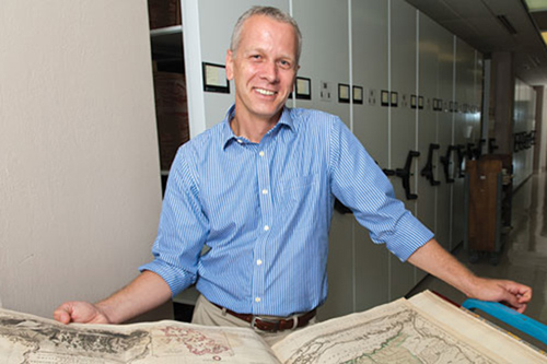 Martin Brückner looks at an atlas in the University of Delaware Library's Special Collections. Photo by Evan Krape