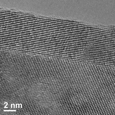 An image of the yttria-stabilized zirconia film (parallel rows near the top) on top of a sapphire substrate (spotted array near the bottom) created using a transmission electron microscope. Bright spots indicate rows or columns of atoms and demonstrate that the distance between the rows of yttria-stabilized zirconia atoms increase in such thin films. Photo by Kathy F. Atkinson
