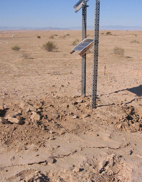 A solar-powered creepmeter beside cracks generated by a creep event on California's Superstition Hills Fault in 2006. Creep events are slow and silent, last hours, and can accommodate approximately 3 centimeters of slip per event. (Photo courtesy of Matt Wei)