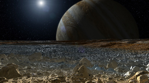 This artist's concept shows a simulated view from the surface of Jupiter's moon Europa. Europa's potentially rough, icy surface, tinged with reddish areas that scientists hope to learn more about, can be seen in the foreground. The giant planet Jupiter looms over the horizon. Image credit: NASA/JPL-Caltech