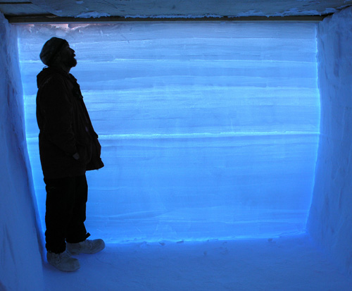 A West Antarctica Ice Sheet Divide project researcher stands in a snow pit next to an ice core with data from 68,000 years ago. The prominent line across the middle of the ice separates one year’s ice and snow accumulation from the next year’s. Image credit: Kendrick Taylor/Desert Research Institute