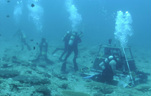 Glenn McDonnald, Scott Gallager, and Amber York of WHOI and Koichi Toda of OIST installing the OceanCube central node in waters off Okinawa, Japan. (Photo courtesy of OIST)