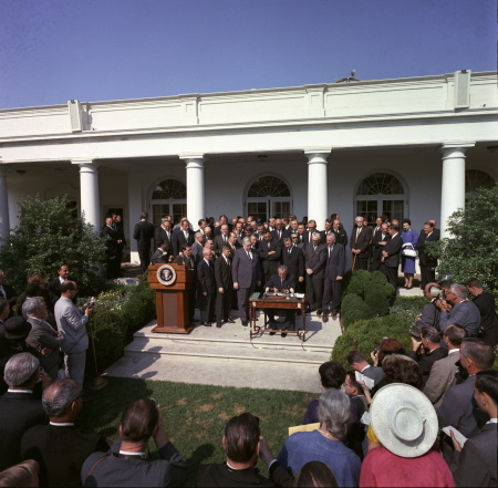 President Johnson signing the Economic Opportunity Act of 1964. Image credit: Wikipedia