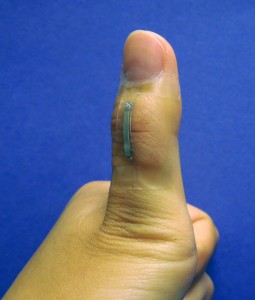 A sensor based on silver nanowires is mounted onto a thumb joint to monitor the skin strain associated with thumb flexing. The sensor shows good wearability and large-strain sensing capability. Photo credit: Shanshan Yao (Click image to enlarge)