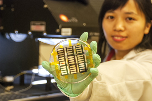 UCLA postdoctoral researcher Huanping Zhou displays perovskite solar cells made using a vapor-assisted solution process. The process has shown potential for inexpensive manufacturing of high-efficiency solar cells. Image credit: University of California