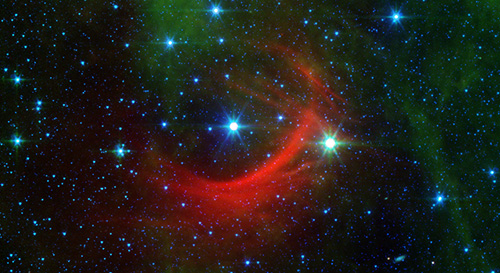 The red arc in this infrared image from NASA's Spitzer Space Telescope is a giant shock wave, created by a speeding star known as Kappa Cassiopeiae. Image credit: NASA/JPL-Caltech 