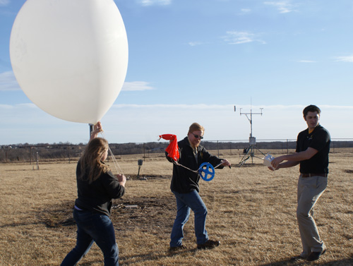 Katie Crandall, doctoral candidate in atmospheric science, Patrick Market, professor of atmospheric sciences, and Josh Kastman, doctoral candidate in atmospheric science, prepare to launch a weather balloon. These balloons carry data-collecting devices that pass through elevated convection events in the atmosphere, radioing back data that will provide clues as to why this phenomenon triggers heavy rain-producing thunderstorms. Image credit: University of Missouri