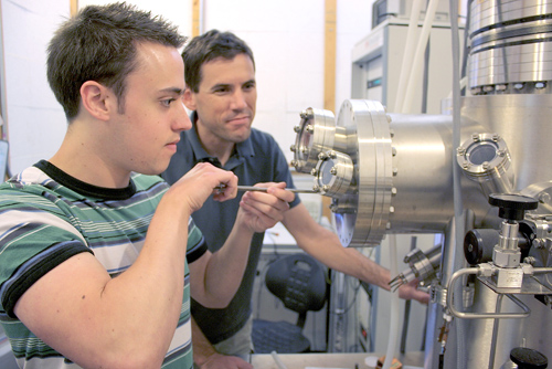 Brian LeRoy, UA associate professor of physics (right) and graduate student and first author of the study, Matthew Yankowitz, use a tunneling electron microscope to probe the electronic properties of graphene. (Photo by: Daniel Stolte/UANews)