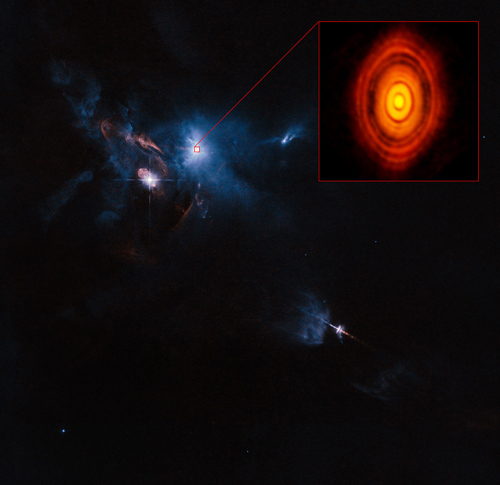 Dies ist eine Kompositaufnahme des jungen Sterns HL Tauri und seiner Umgebung, die Daten von ALMA (vergrößerte Box oben rechts) und des NASA/ESA Hubble Space Telescopes (restliches Bild) verwendet. Es ist die erste Aufnahme von ALMA, in der die Schärfe des Bildes die normalerweise erreichte Schärfe des Hubble-Weltraumteleskops übertrifft. Image credit: ALMA (ESO/NAOJ/NRAO), ESA/Hubble and NASA. Acknowledgement: Judy Schmidt