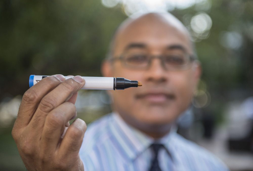 Assoc. Prof. Jayant Pinto is pictured with a “Sniffin’ Stick,” an aroma-loaded device used to test patients’ ability to identify scents for research on olfactory dysfunction and aging. Photo by Robert Kozloff