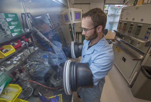 Carter Abney works in a glovebox in the Gordon Center for Integrative Science to handle chemicals that are sensitive to water and air. Abney, a graduate student in chemistry at the University of Chicago, has received a 2014 Innovations in Fuel Cycle Research Award for his work on metal-organic frameworks. Photo by Robert Kozloff