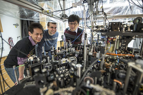 University of Chicago scientists can create an exotic, particle-like excitation called a roton in superfluids with the tabletop apparatus pictured here. Posing left to right are graduate students Li-Chung Ha and Logan Clark, and Prof. Cheng Chin. Photo by Rob Kozloff