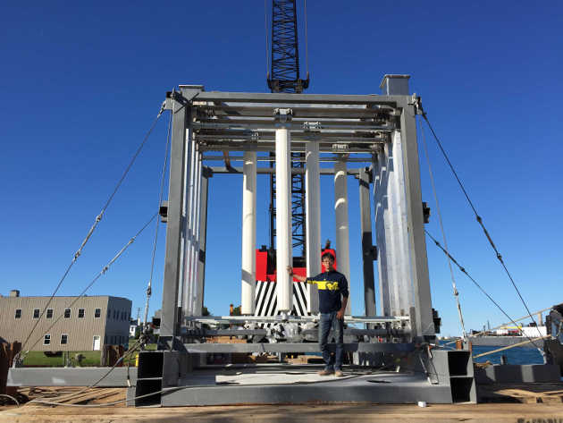 Mechanical engineer Eun Soo Kim with the Vivace device, shortly before its deployment in June of 2016. The indentations on the surface of the cylinders will help water currents push them back and forth, increasing the device’s efficiency. Image courtesy: Vortex Hydro Energy