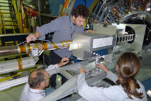 The Heavy Flavor Tracker during insertion into the STAR detector. Pictured at bottom left is Howard Wieman, the lead designer of the HFT. (Image credit: Leo Greiner/Berkeley Lab)